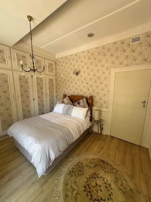 Bedroom 2 pine bed and floral wallpaper