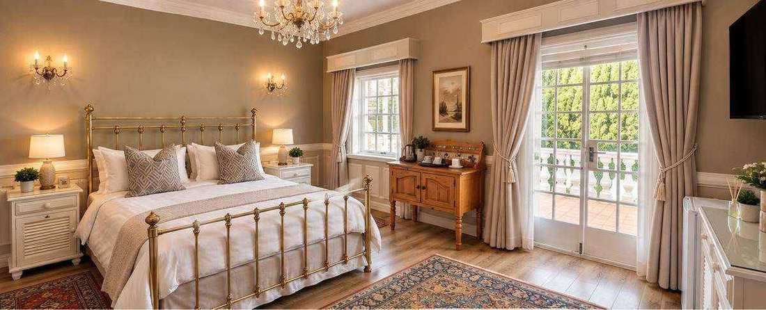 Manor Residence Suite bedroom with brass bed and French doors to its balcony