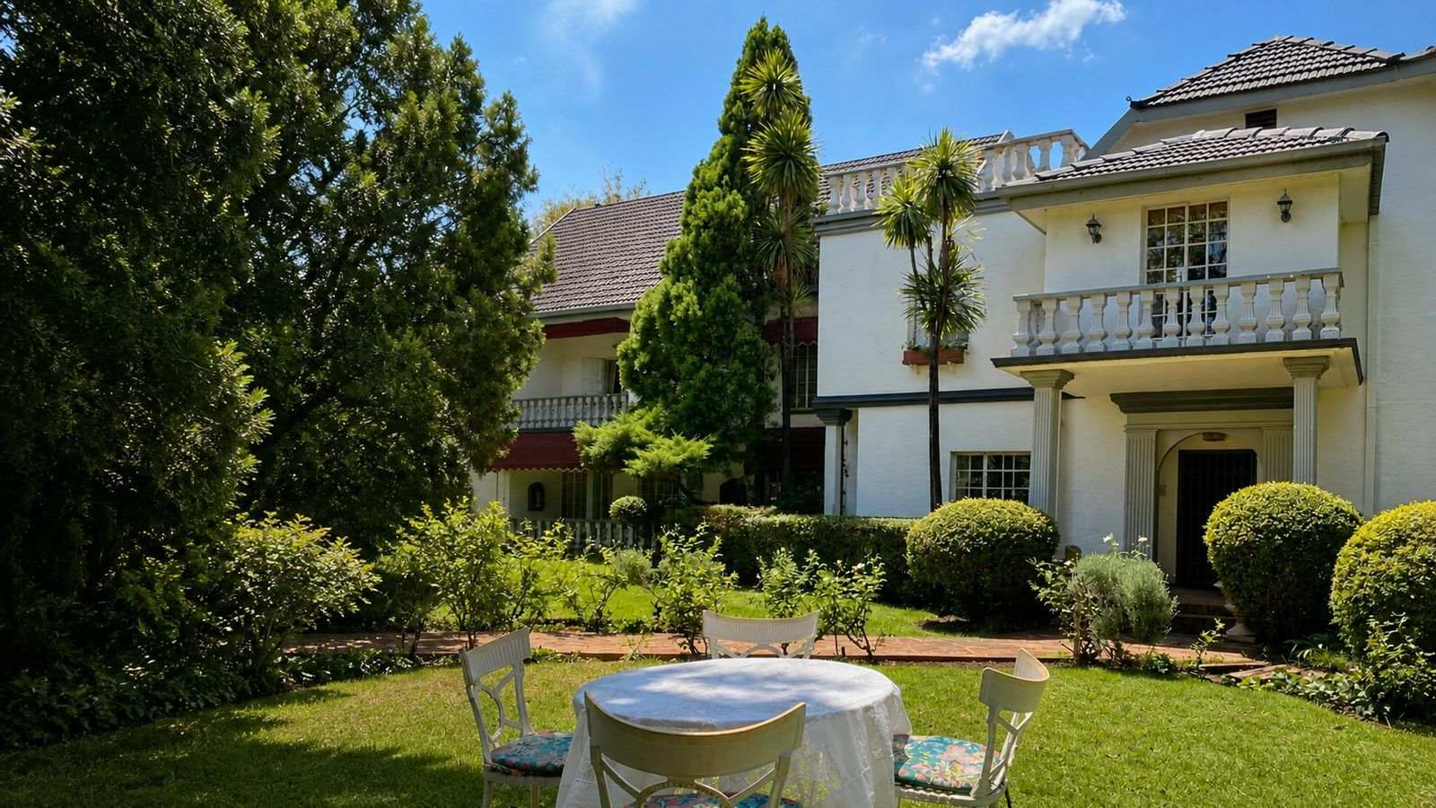 Garden Court's classic white façade beyond a sunny green lawn