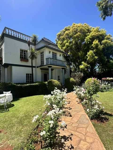 Garden Court house beyond a rose-lined garden path